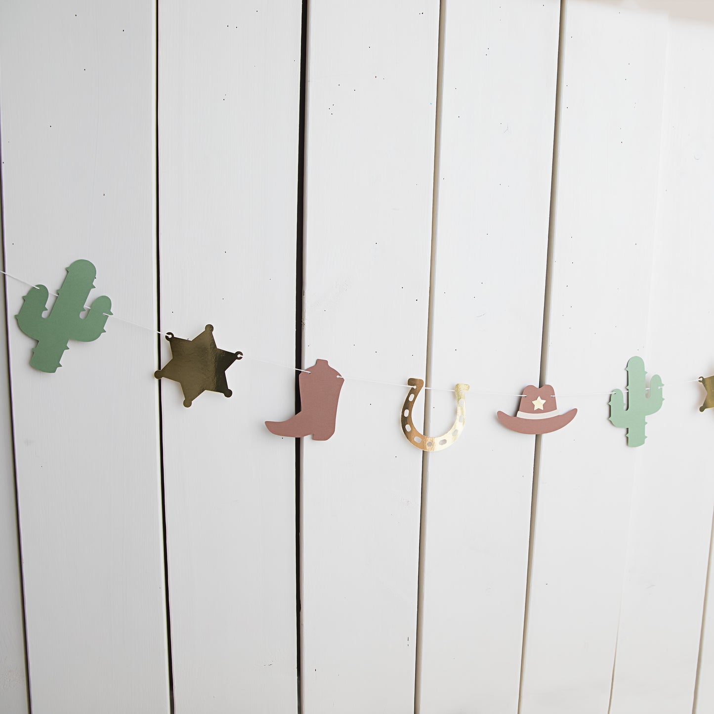 My first rodeo paper garland with cowboy boots, sheriff badges, cacti and cowboy hats