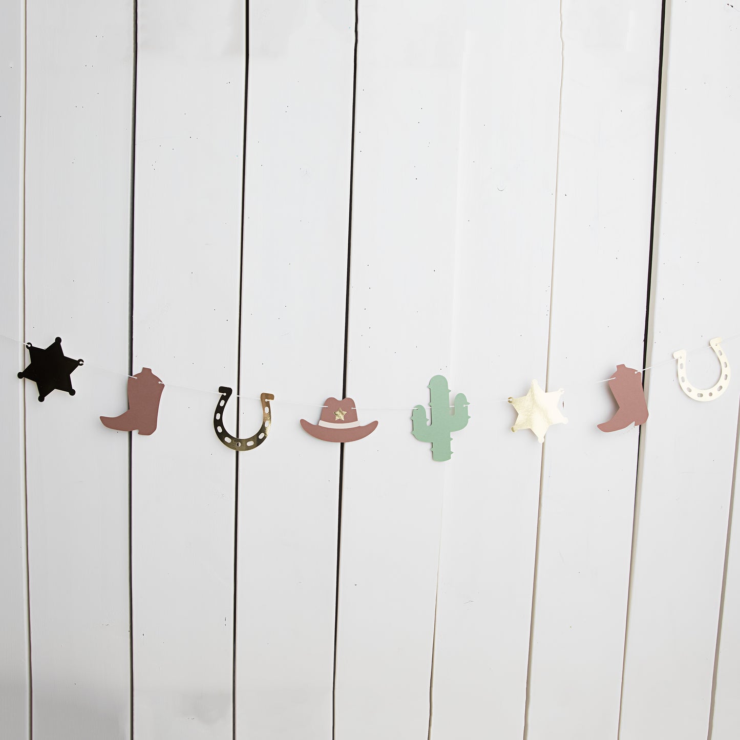 My first rodeo paper garland with cowboy boots, sheriff badges, cacti and cowboy hats