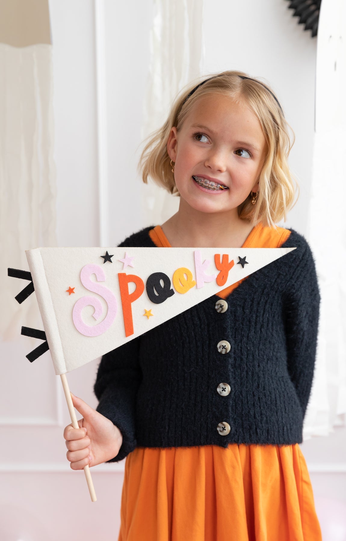 child holding the spooky felt pennant banner