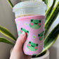 Neoprene drink sleeve that’s pink with cute frogs and daises on it 