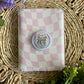 disco planter e reader grip laying on top of pink/ white checkered case 