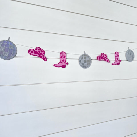 disco cowgirl themed garland with disco balls, pink cowboy boots and pink cowboy hats