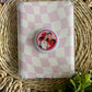 checkered e reader case with heated rivalry grip laying on top