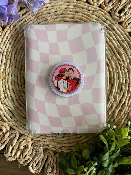 checkered e reader case with heated rivalry grip laying on top