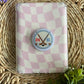 hockey stick e reader grip laying on top of pink/ white checkered case 