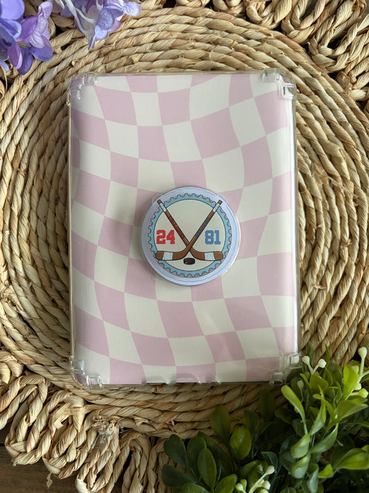 hockey stick e reader grip laying on top of pink/ white checkered case 