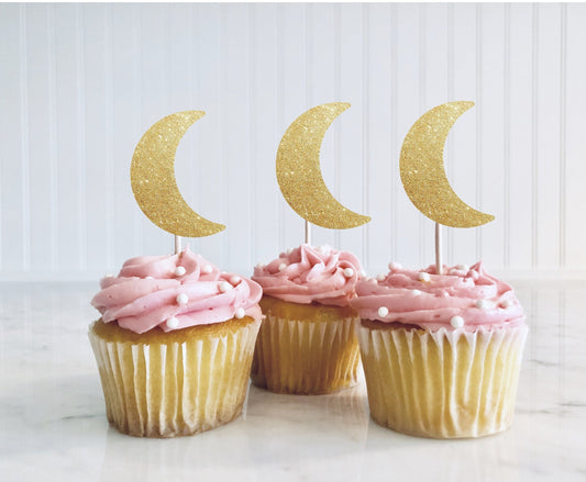 moon shaped cupcake toppers on top of cupcakes