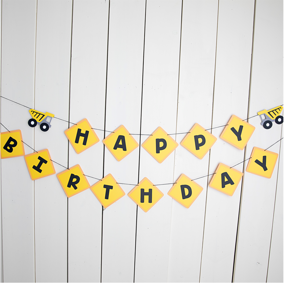 yellow and black construction themed banner featuring dump trucks that says happy birthday