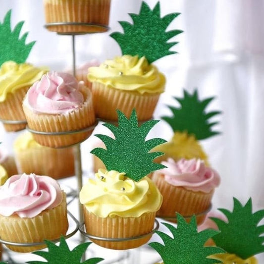 green glitter pineapple tops on top of yellow frosted cupcakes